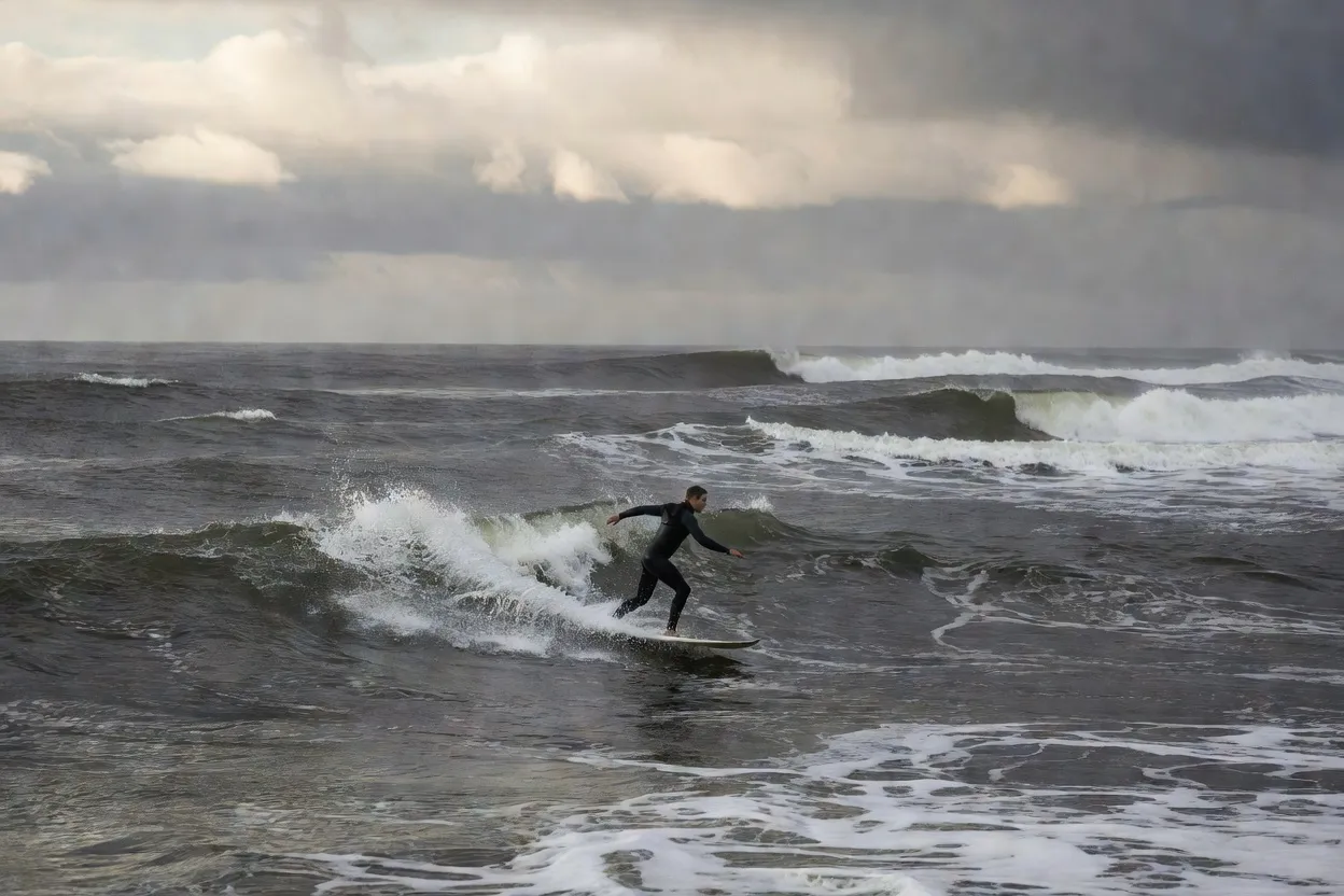 Surfeur en combinaison intégrale dans les vagues de Long Beach à Tofino, île de Vancouver