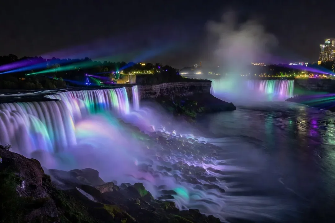 Chutes Niagara illuminées la nuit avec reflets colorés dans les gorges